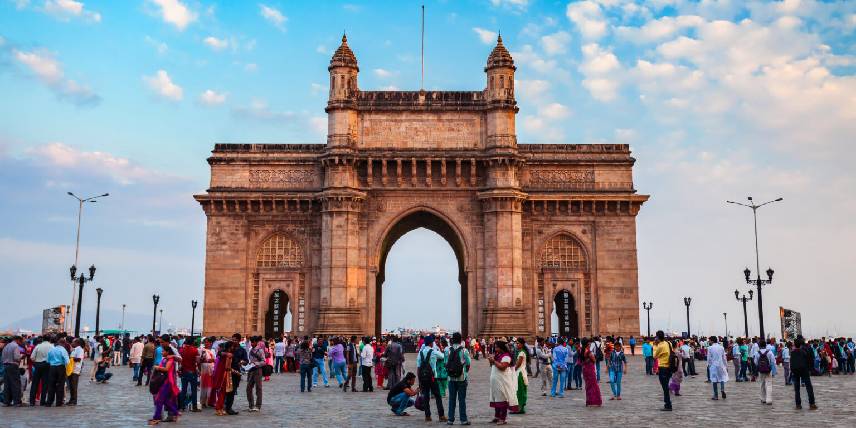 Crowds at Gateway of India monument overlooking Mumbai harbor at sunset